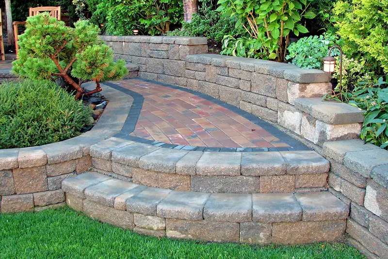 Muro de piedra junto a un patio pavimentado
